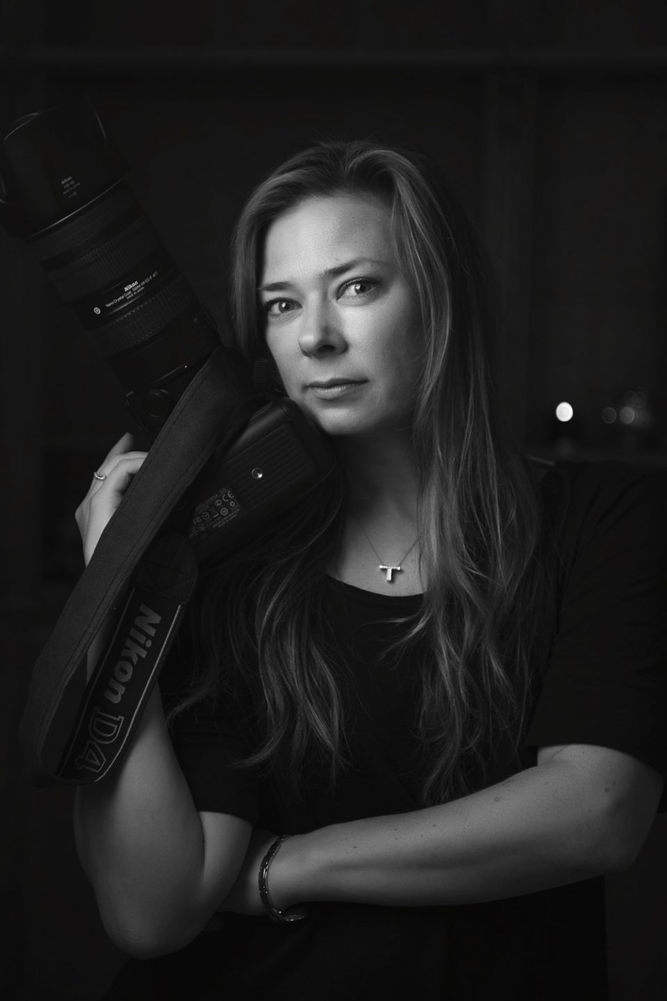 black and white photo of melbourne photographer Tanya wilson photographer posing with camera near face
