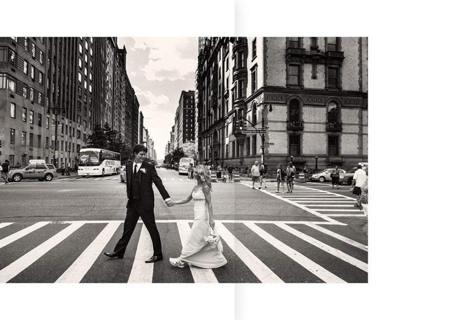 Groom leads bride dressed in sneakers, across a pedestrian crossing on the busy streets of New York on their wedding day