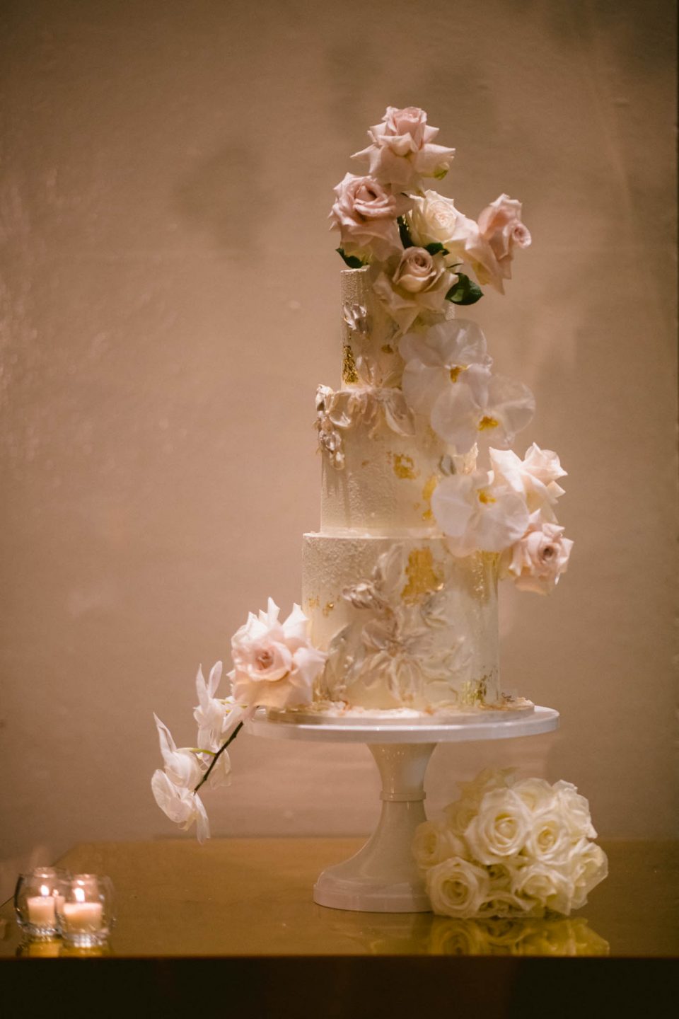 cake decorated in fresh pink and white roses on wedding day
