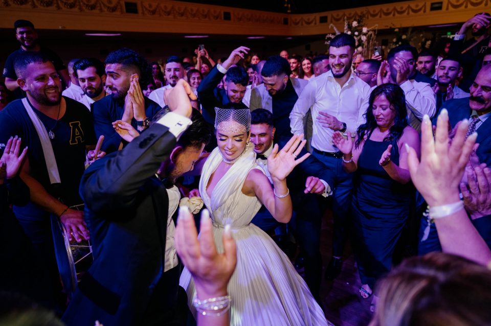 Bride and groom dancing with many guests on the dance floor of the wedding reception Melbourne town hall