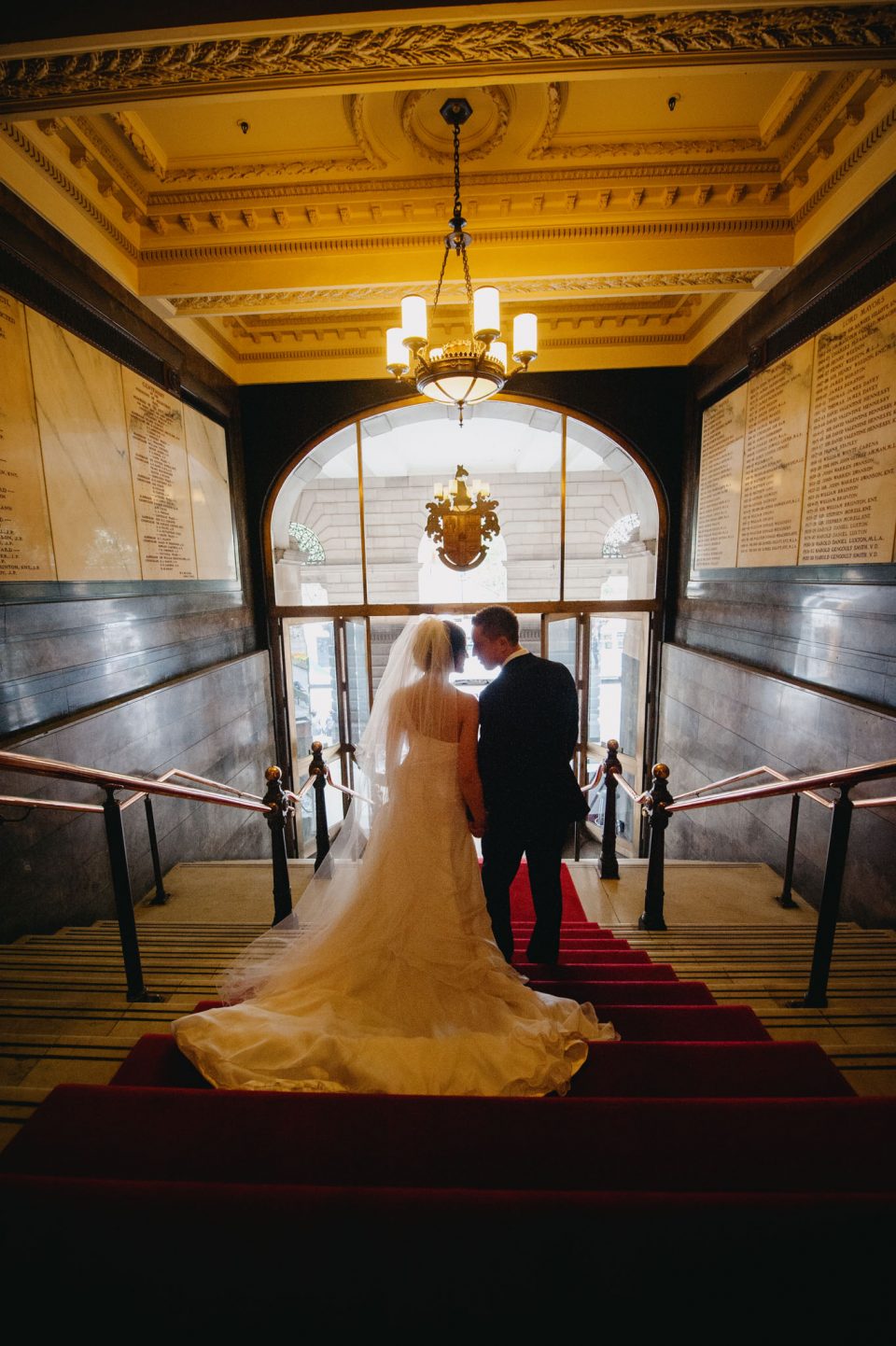 couple walk away down the stairs fo Melbourne Town hall