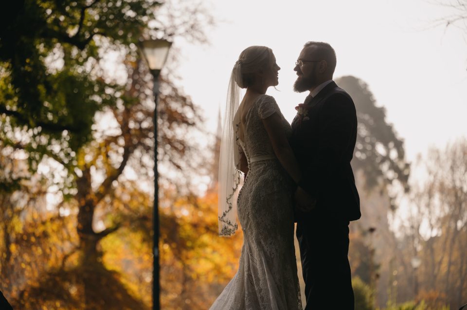 wedding couple in fitzroy gardens looking at each other with autumn colours in the background