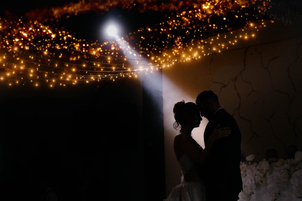 first dance of wedding couple, spotlight shining on them