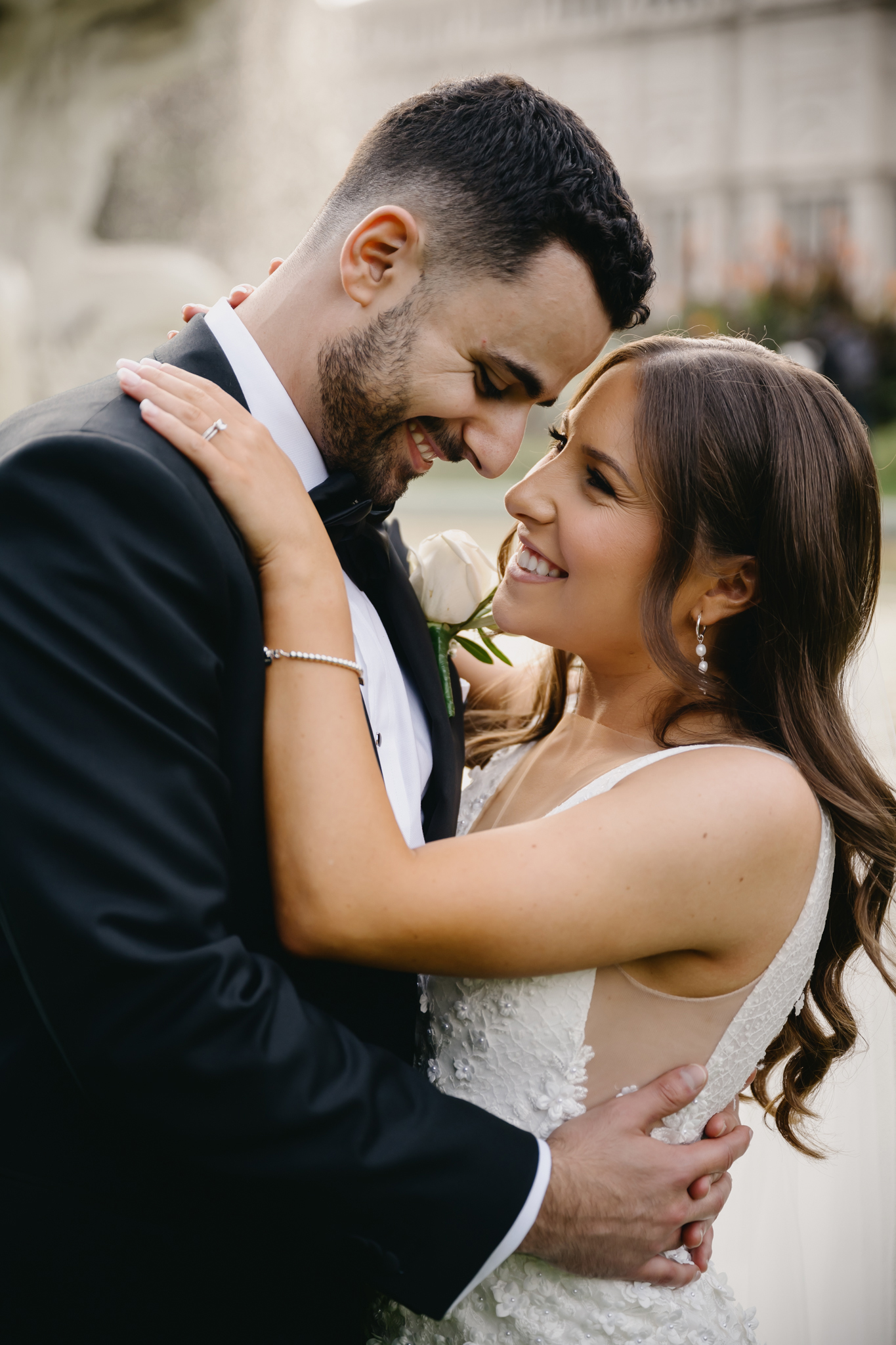 bride and groom at Carlton gardens fountain looking smiling at each other