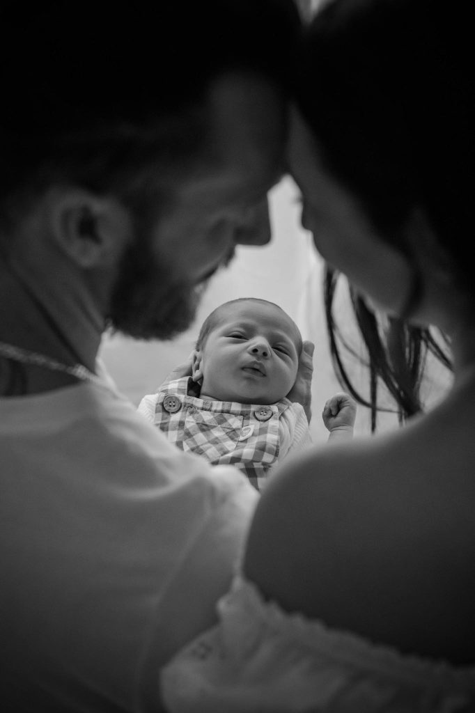 black and white portrait photo parents looking at their new born baby