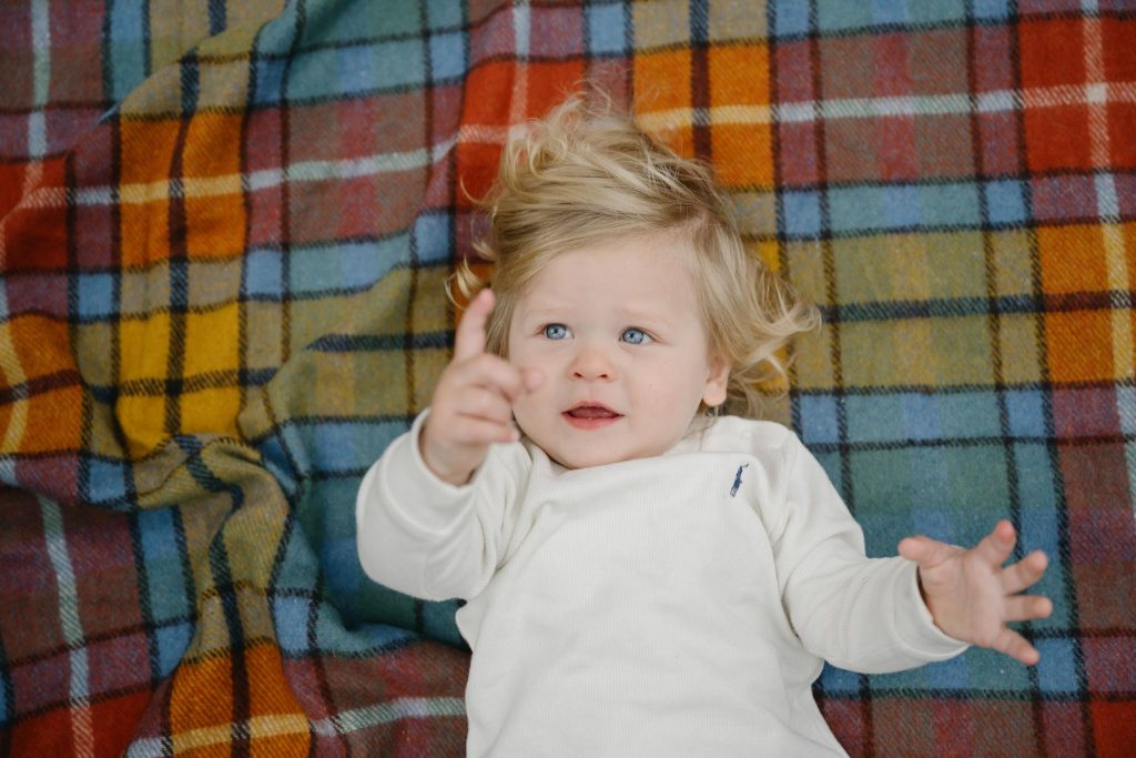 portrait of one year old laying on picnic rug in Melbourne park