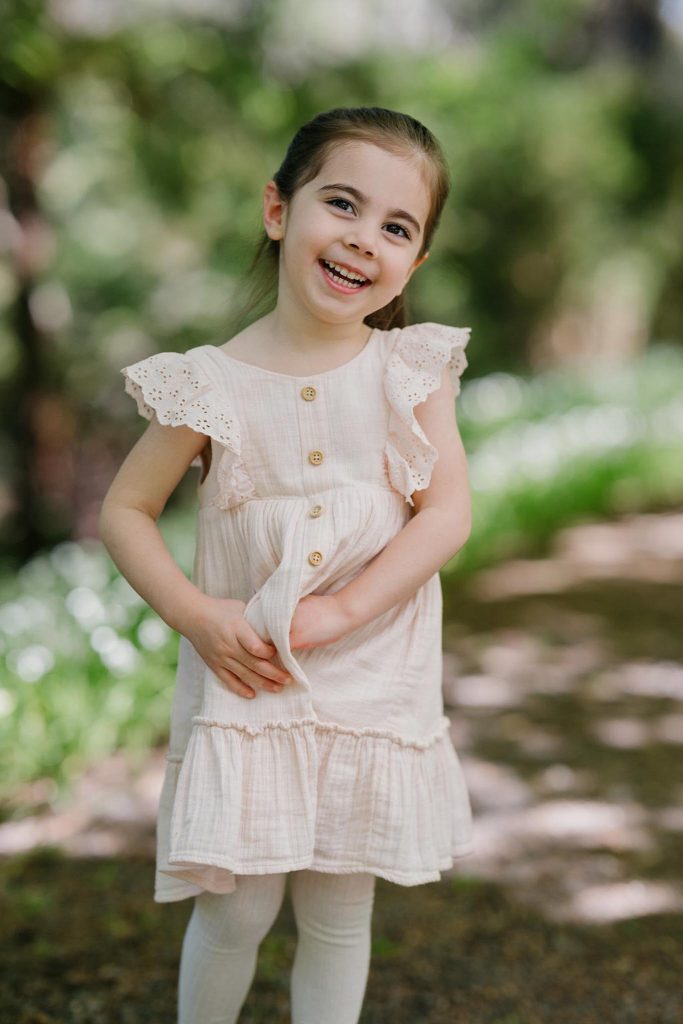 four year old smiles for the camera having her photo taken in Melbourne