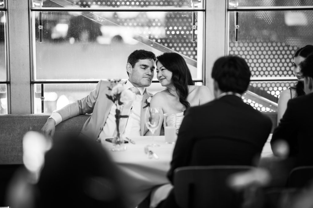 Bride and groom seated during reception speeches at Taxi Kitchen wedding